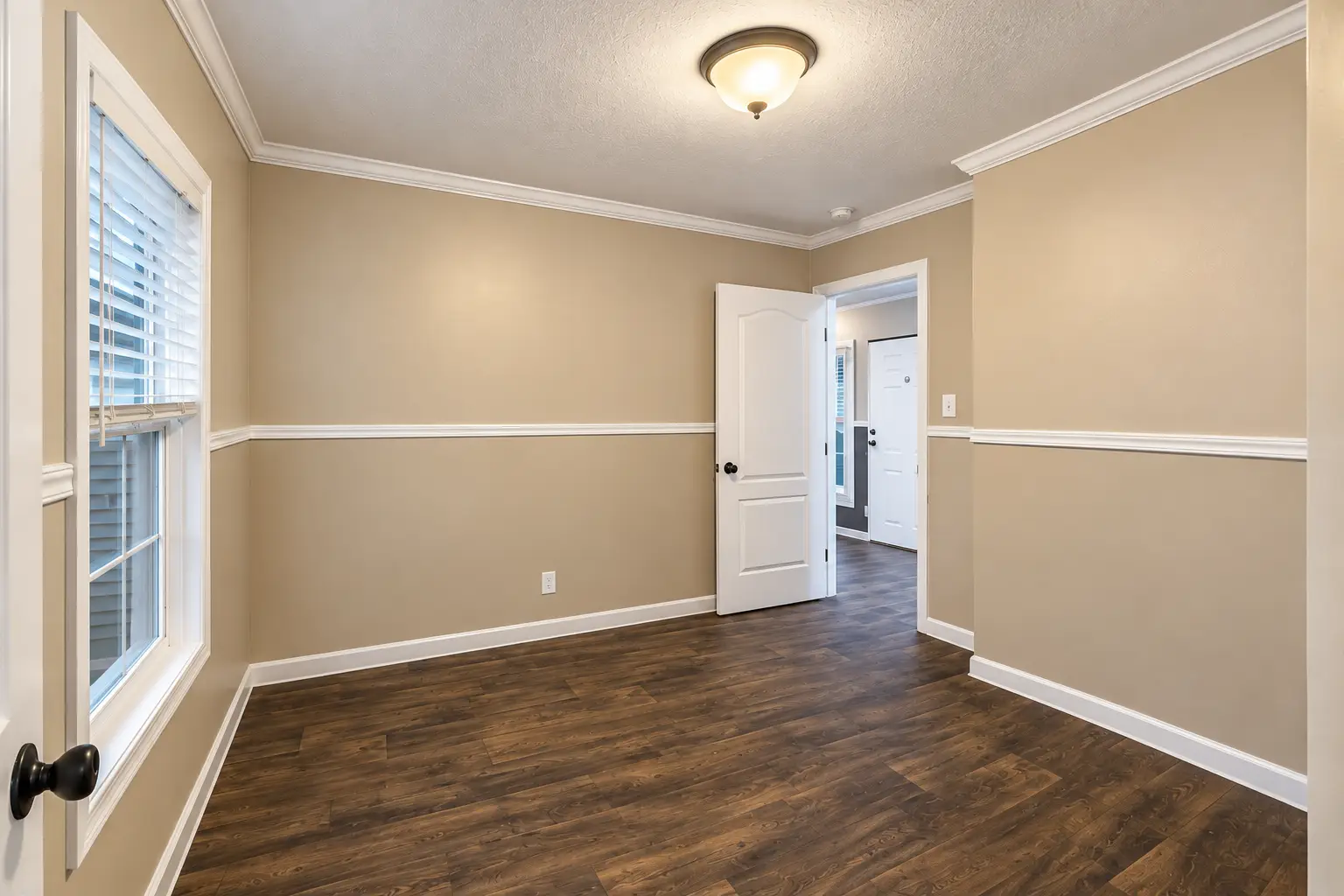 Empty Beige Bedroom with Open Door Starter Home. Downsizing Dream. Affordable Living. Your Move.